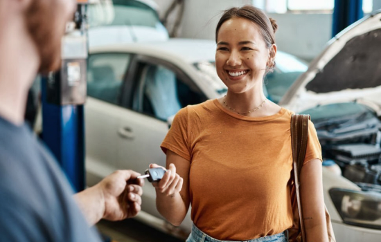 A worker giving car key for a woman